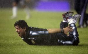 Diego Maradona dives onto the ground as he celebrates his teams second goal during their World Cup 2010 qualifying